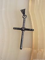 Front view of sterling silver cross pendant showing knot detail and bail