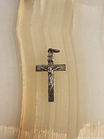 Front view of sterling crucifix pendant showing corpus detail and bail