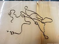 Full view of tangled sterling silver box chain showing break