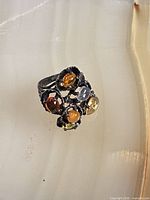Front view of sterling silver ring showing clustered multicoloured stones
