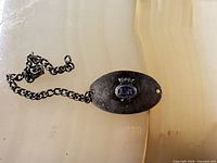 Front view showing enamel MN crest and attached chain