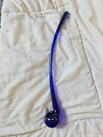 Full view of cobalt blue glass hand pipe on white fabric