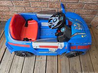 Top-side view showing full ride-on car layout, seat, steering wheel, windshield panels.