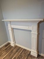 Front view of white fireplace mantel surround showing overall design and finish