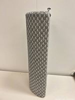 Side profile of gray geometric bolster pillow