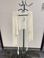 Full view of white tie-front knit cardigan on hanger