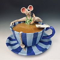 Full view of papier-mâché mouse sculpture in blue striped teacup and saucer