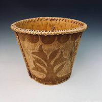 Full view of birch bark bucket showing exterior design and rim stitching