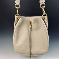 Front view of stone leather shoulder bag with tassel and gold hardware