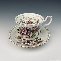 Teacup on saucer showing floral motif and gold trim