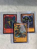Front view of all three cards in sleeves: Leonardo, Finesse, Chimera