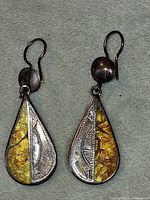 front view of both earrings showing amber chip inlay and silver-tone details