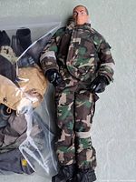Full view of figure beside bag of extra gear