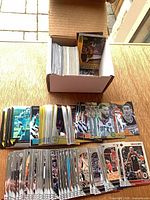 Open card storage box with large stack of sleeved and unsleeved NBA cards displayed in rows