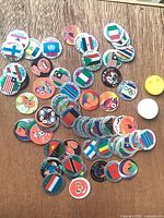 Group shot of entire assortment of pogs/tazos scattered on table