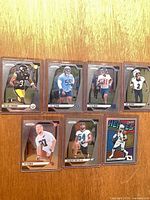 All seven cards sleeved and top-loaded displayed on wood surface