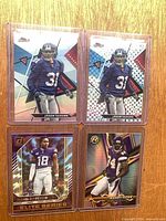 Four sleeved and toploaded football cards laid out