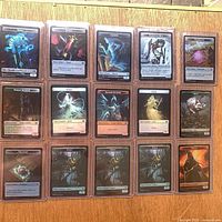 Grid overview of 15 sleeved token cards in toploaders