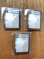 Three stacks of cards sealed in plastic bags