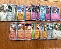 Front view showing two rows of silver-border reverse holo Pokémon cards spread on table