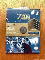 Front view of sealed Breath of the Wild coin collector album showing artwork and display coin