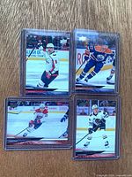 Group shot of four Upper Deck hockey cards in top loaders