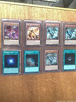 All eight cards in two rows, each in toploader