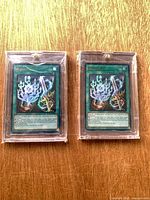 Front view of both Runick Tip Spell cards in protective cases