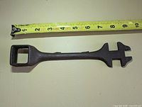 Full view with tape measure showing length, square socket left, double open-end right
