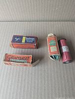 Four rolls of boxed/wrapped film arranged on cardboard