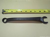 Full view of Ford offset wrench next to tape measure showing length