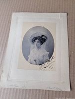 Front view showing portrait, signature, mount and corner tear