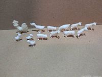 All fifteen white plastic MPC farm animal figurines lined up