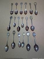 All 18 silver-plated spoons laid out showing varied designs and wear