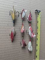 All eight lures beside measuring tape showing approximate 2-3 inch length