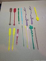 Group shot of all 15 plastic swizzle sticks laid out to show colours and shapes
