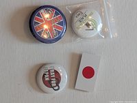 Four pinback buttons laid out: British Punk, I Pray for Japan, Thorncliffe Life Place, Japanese flag