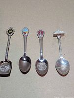 Four souvenir spoons laid side by side