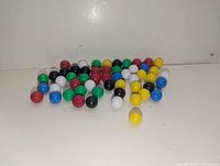 Pile of multicolour plastic marbles on white surface