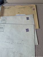 Group of manila and off-white envelopes showing stamps and addresses