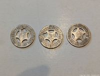 Obverse of three tokens showing dates and divisions