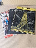 Front covers of the three sheet music books arranged together