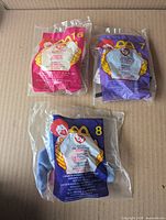 Front view of three sealed Ty Teenie Beanie Baby bags (#16 pink, #7 purple, #8 blue)
