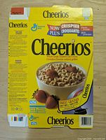 Front panel of first flattened Cheerios box showing cereal bowl graphics and 425 g weight