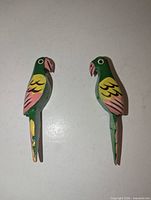 Front view of both carved wood parrots