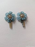 Front view of two blue plastic floral hair clips