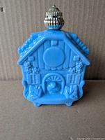 Front of blue cuckoo clock milk glass perfume bottle