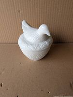 Full view of white milk glass hen on nest candle holder with lid in place
