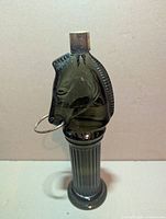 Full view of green glass horse-head decanter on pedestal