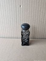 Front view black glass Avon Wild Country travel bottle